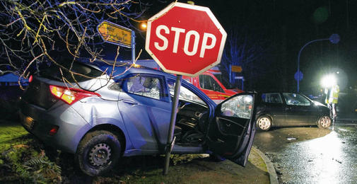 Autoheck auf Felssteinmauer hinter Stopschild